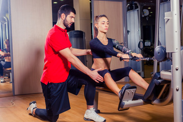 Personal trainer working with his client in gym