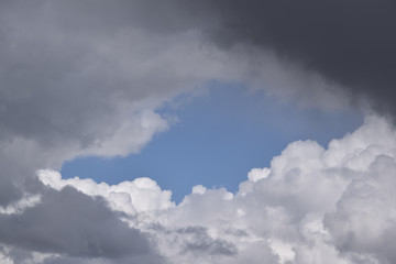 Loch in Wolken und blauer Himmel