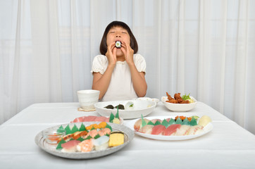 Obraz na płótnie Canvas お寿司を美味しそうに食べる女の子