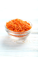 Fototapeta na wymiar Red lentils in bowl on a blue wooden table