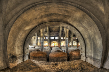 Fototapeta na wymiar View through arch of concrete fermentation tanks in an abandoned