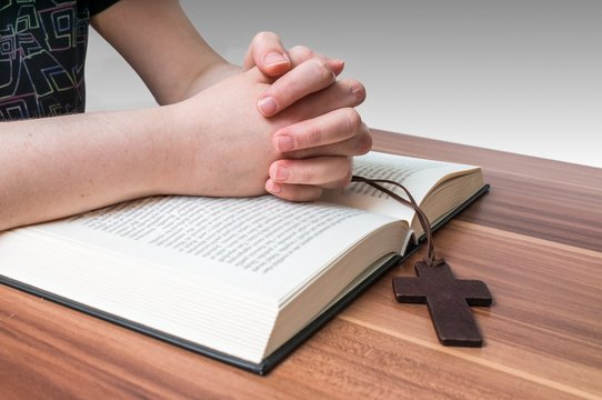 Prayer's hands on bible.