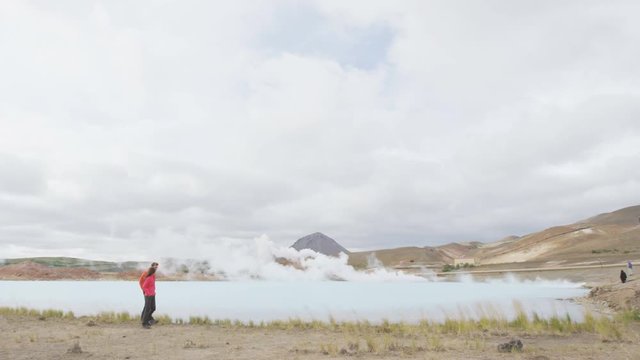 Iceland travel people by geothermal energy power plant and hot spring in Namafjall in Lake Myvatn area. Couple on travel in Icelandic nature landscape, Route 1 Ring Road