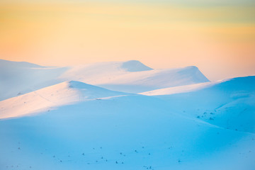 Fototapeta na wymiar Sunset over hills with snow