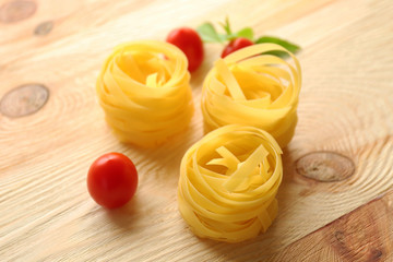 Nests of dry noodles on wooden table