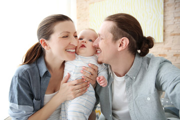 Happy couple taking a selfie with baby , close up