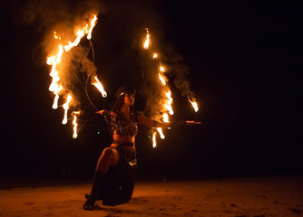 Fire show artist on the beach fire in the dark