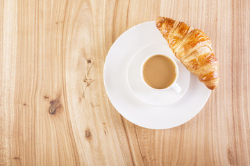 Coffee and croissant on plate