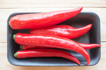 Naklejka premium chillis on wood background