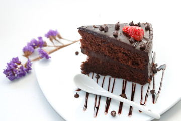 Slice of chocolate layer cake with  strawberries and chocolate s