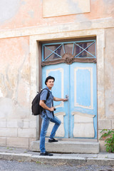 Fototapeta na wymiar Handsome male tourist entering an old building