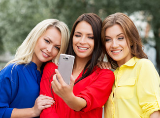 Three women doing a selfie in the park