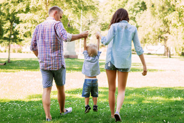 Mother and father holding their son in the park