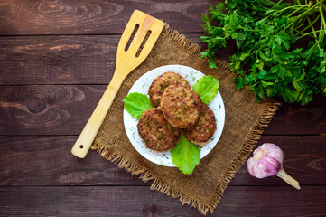 Juicy homemade cutlets (beef, pork, chicken) on a wooden background. For a hamburger. The top view
