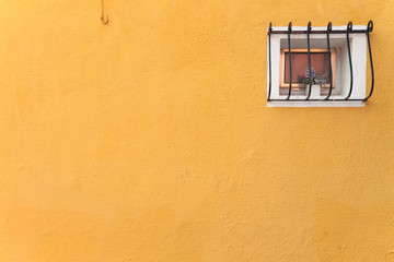 small window from a yellow house in Burano island, Venice