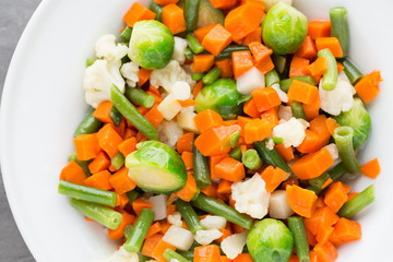 Fresh vegetables mix in a white bowl.