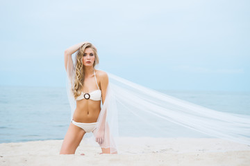 Fototapeta premium Beautiful, sexy girl in white bikini posing on the beach