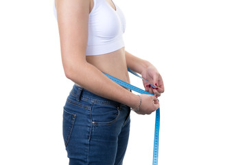 Woman measuring her waist with tape after loosing weight