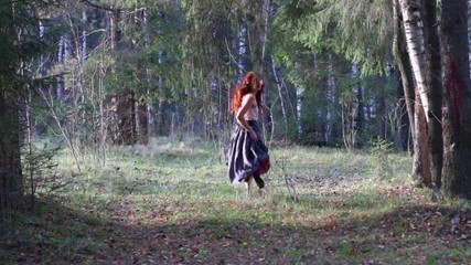 Pretty girl in grey skirt scared and runs away in autumn forest