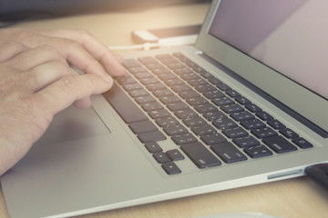 man's hand on computer notebook, vintage tone