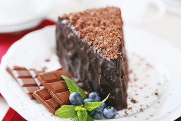 Chocolate cake with chocolate cream on plate, on light background
