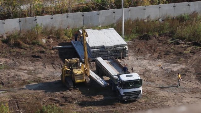 PERM, RUSSIA - SEP 28, 2015: Unloading concrete piles on construction site of largest developer Perm factory of silicate panels