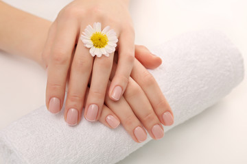 Woman hands with beautiful manicure on white towel, close up