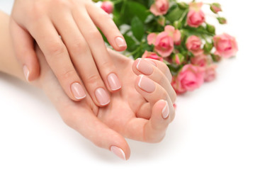 Woman hands with beautiful manicure and roses isolated on white background
