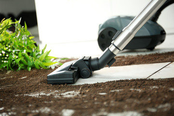 Vacuum cleaning after falling flower pot on a tiled floor