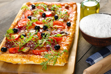 Rectangle delicious pizza and vegetables on the table