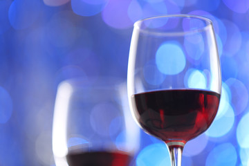 Wineglasses on blue blurred lights background