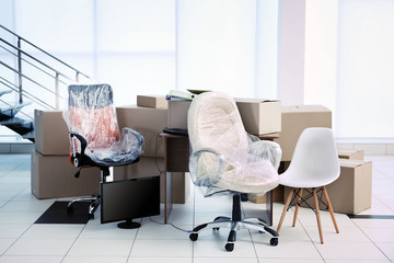 Moving cardboard boxes and personal belongings near stairs in office