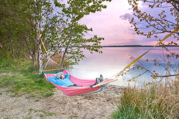 Strandurlaub am See, Frau erholt sich in einer Hängematte