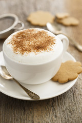 Cappuccino in white cup with cinnamon