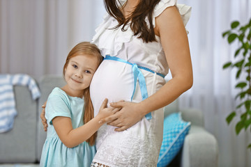 Fototapeta premium Pregnant woman and her happy child hugging