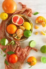 Fresh citrus fruits with green leaves on wooden table closeup