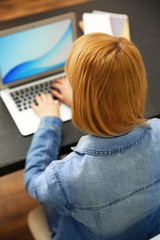 Woman working on a laptop at office desk