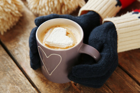 Woman Hands In Mittens Holding A Cup Of Coffee