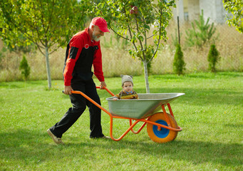 cute little boy sitting in wheelbarrow