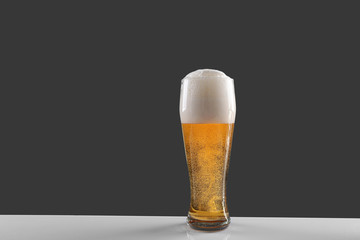 Glass of lager beer on grey background