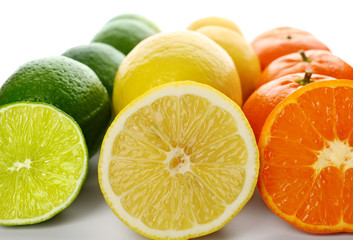 Fototapeta na wymiar Colorful mixed citrus fruit sliced and lined up in rows isolated on a white background, close up