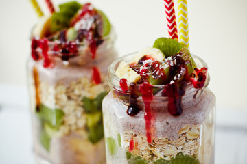 Healthy breakfast over night oats with fresh fruit kiwi and bananas in a glass jar. Beautiful oatmeal
