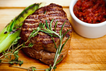 Beautiful juicy well done steak with sauce on a wooden Board