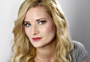 Fototapeta premium Beautiful blond woman looking to the camera. Portrait of a young woman, low key shot.