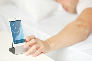 Male hand reaching to a alarm clock