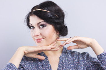 Beautiful brunette on a gray background.Eyelash extensions. Lip augmentation. nail extension
