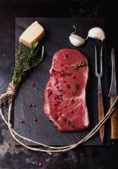 Raw striploin beef steak on black background