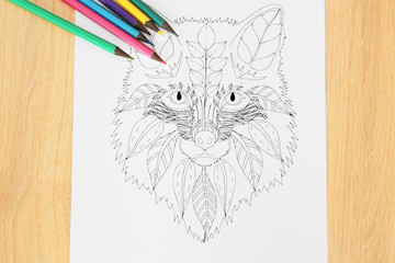 Adult anti stress coloring and soft tip pencils on wooden table, top view