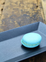 single lonely macaroon on black plate