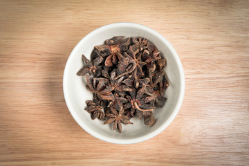 bowl of anise seed on a wood background
